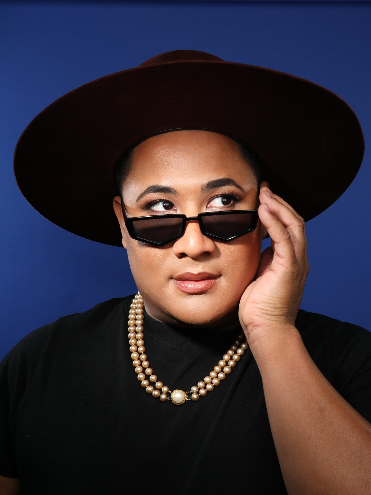 James Ijames is pictured in a black and white picture. They have dark facial hair, are wearing a light beanie, and have glasses framing their face.